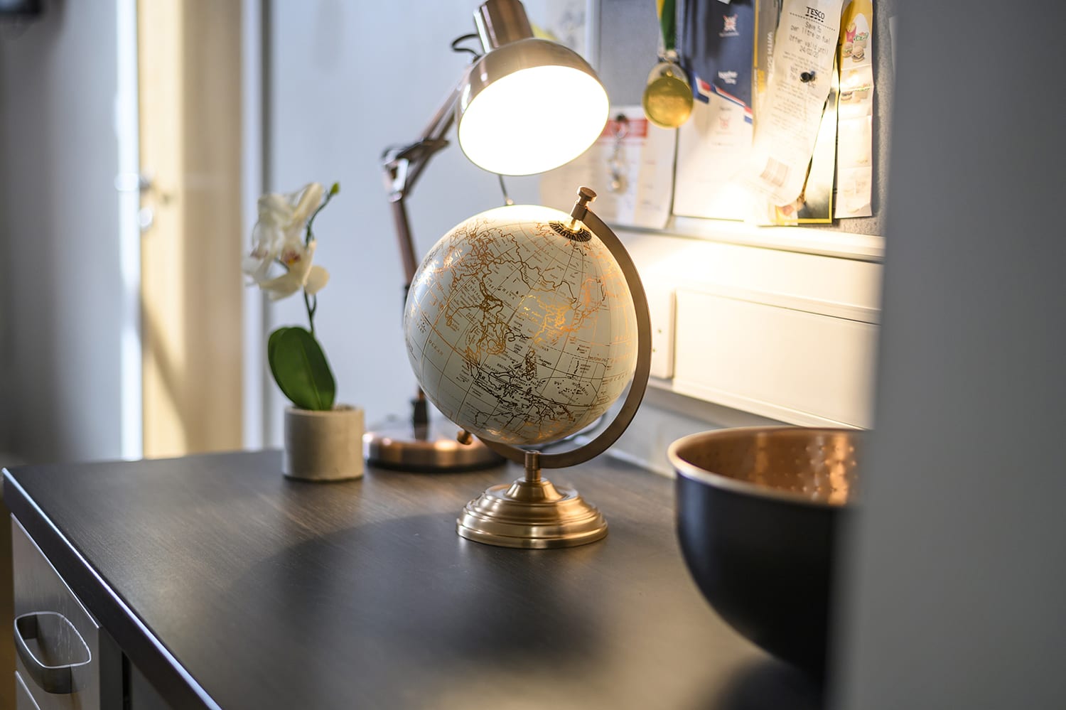 a world globe on top of a desk in a student bedroom