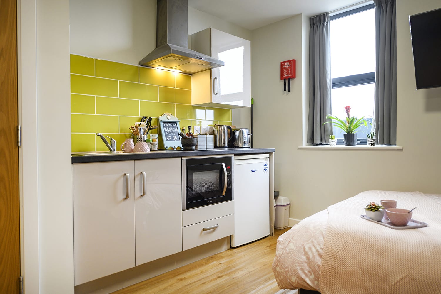 small studio kitchen at the end of student's double bed