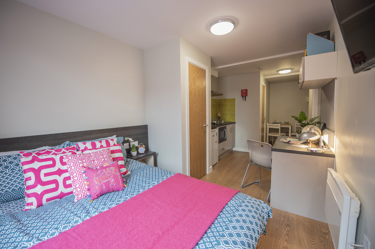 Full view of studio accommodation at Chronicle House including a bed, kitchen and desk